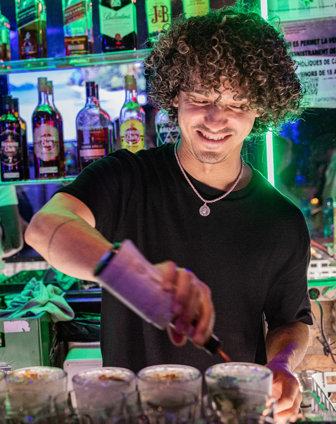 Miembro del equipo preparando cócteles en la barra de El Sabor Cubano