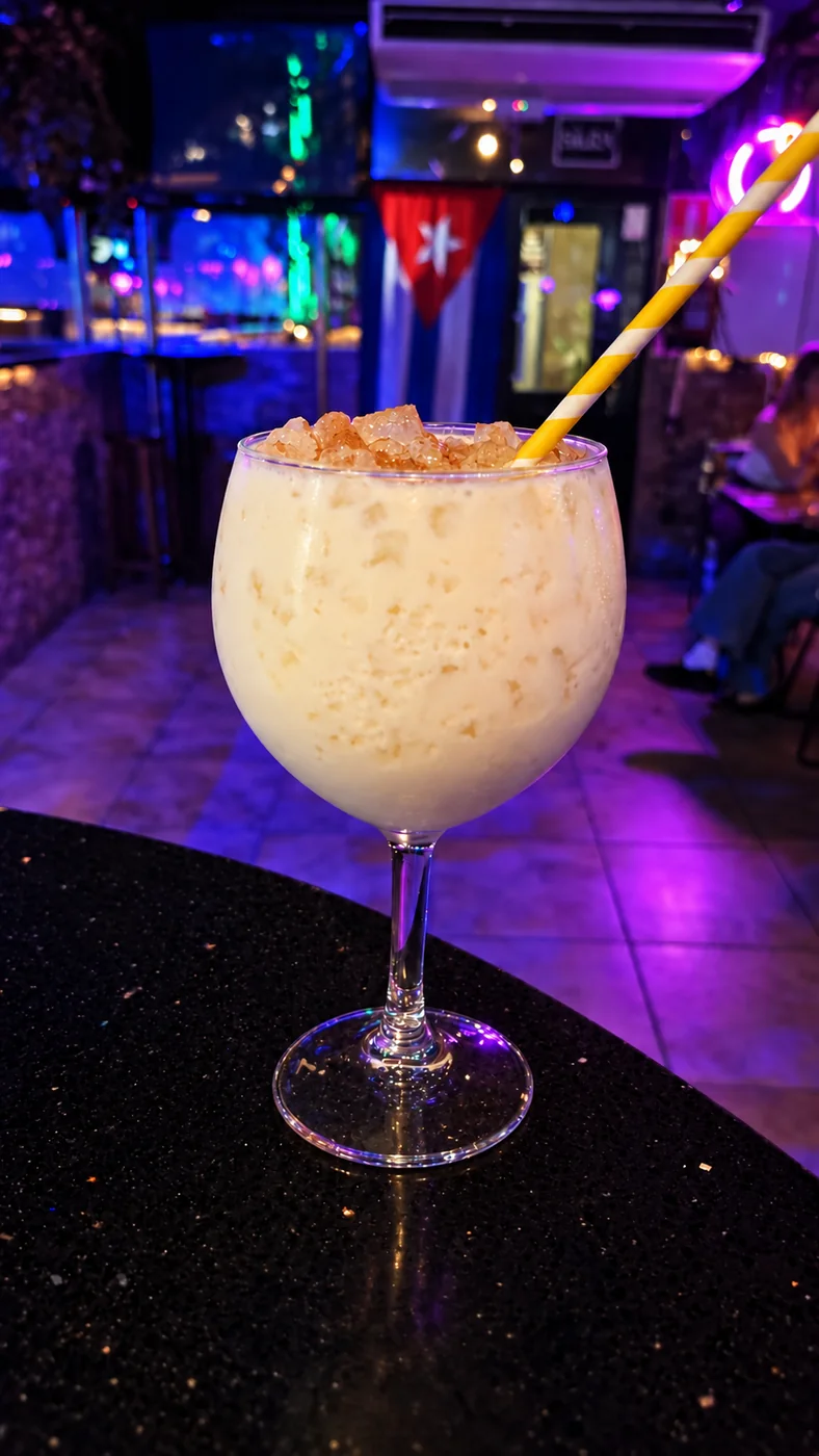 Cóctel cremoso en copa de balón en la barra de El Sabor Cubano